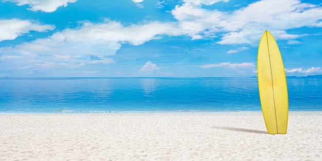 夏のコンセプトチラシ。背景にビーチ、砂と海または海とサーフィンボード。青い水と雲と空。休暇、夏、リゾート。広告用のコピースペース。アートコラージュ。