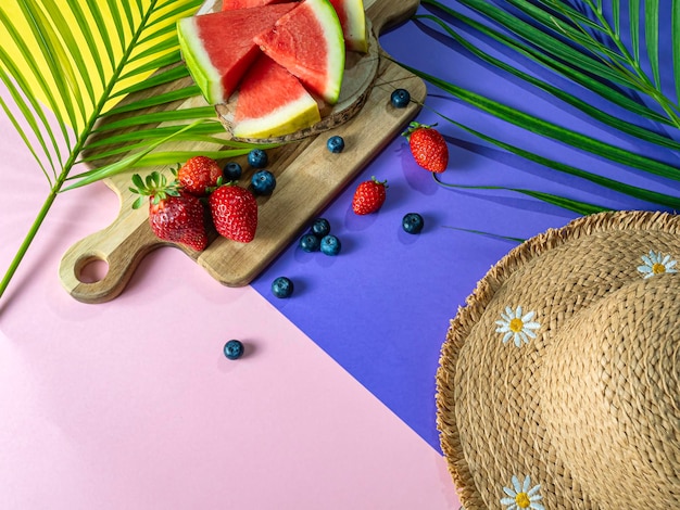 Summer concept Horizontal photo of fresh watermelon red fruits and straw hat on tricolor background