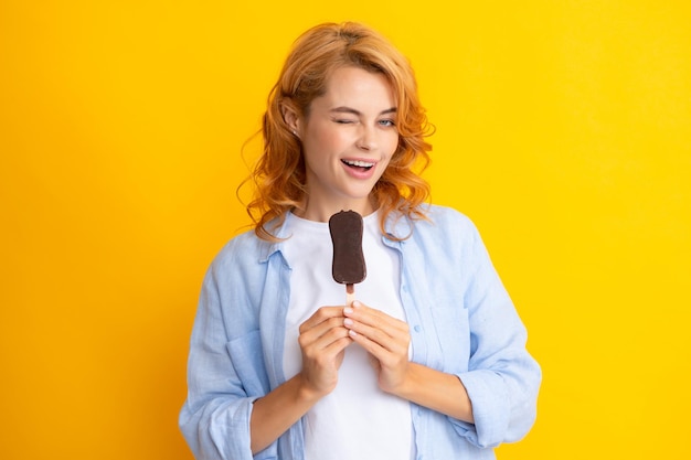 Summer concept Winks woman holds tasty frozen ice cream enjoys eating delicious cold dessert poses