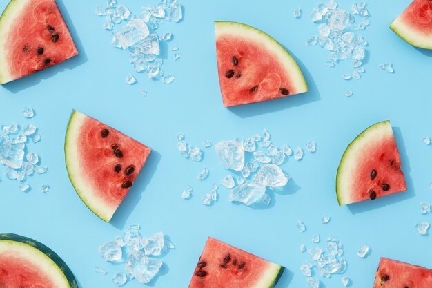 Summer creative wallpaper watermelon pattern with sunlight sliced fruit with ice on blue background