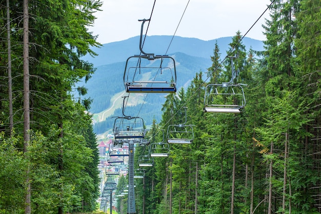 Photo summer day view of ski elevator in mountains.