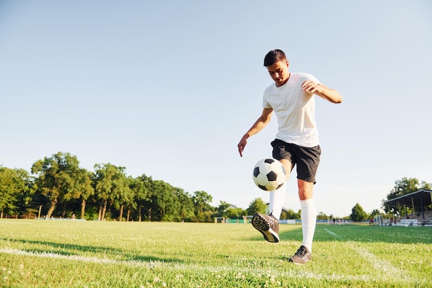 夏の昼間の若いサッカー選手は、スポーツ分野でトレーニングを受けています