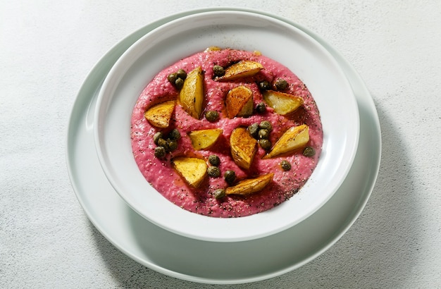 Summer dish with pink hummus from cannellini beans and beets with fried potatoes