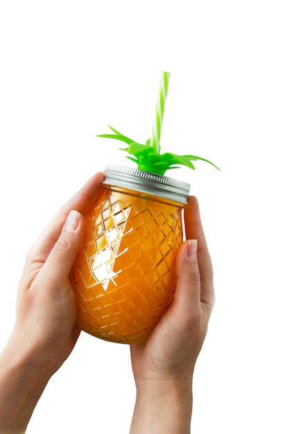 Summer drink, juice or cocktail. woman's hand holding pineapple mason jar filled with orange juice