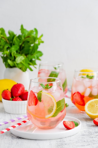 summer drink - strawberry lemonade with mint and ice cubes in glass.