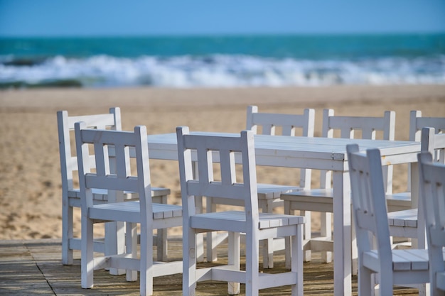 Summer empty outdoor cafe on the seashore at sunrise