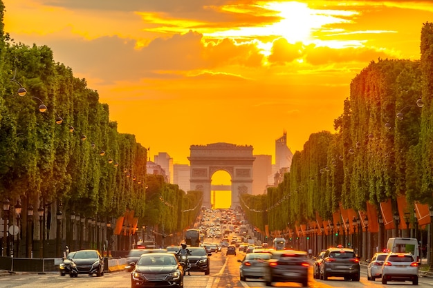 Summer evening in Paris with traffic and the arc de triomphe in the golden sunset