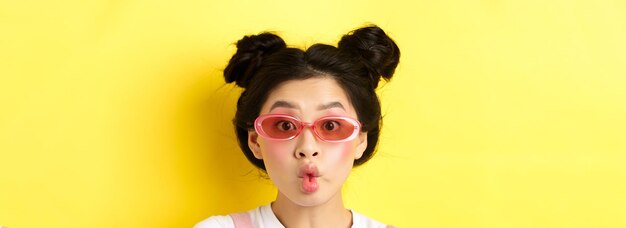 写真 夏のファッションコンセプト サングラスをかけた愚かな魅力的な女の子 魚のように唇をくっつけて 面白く見える