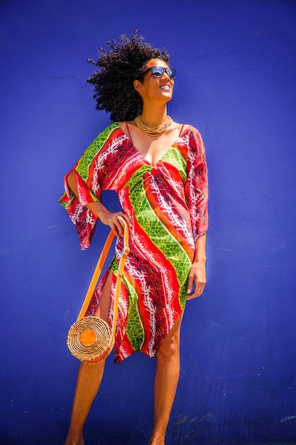 Summer fashion, girl dressed with colorful clothes on blue background