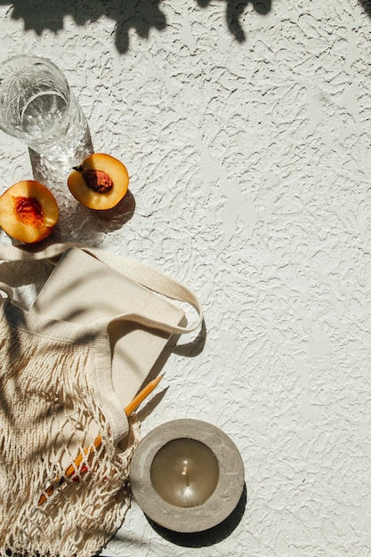 Photo summer flat lay on a concrete background notepad peaches and an ecofriendly mesh shopping bag