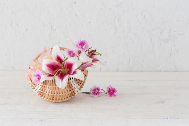 Summer flowers in basket on white