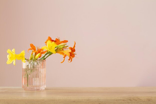 木製の棚の上のガラス花瓶の夏の花