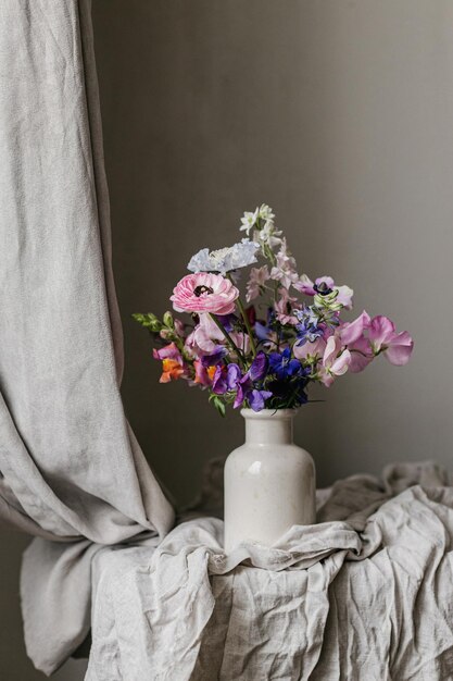 Photo summer flowers in vase rustic moody still life beautiful colorful anemone ranunculus lathyrus scabiosa on aged bench with linen cloth floral moody wallpaper space for text