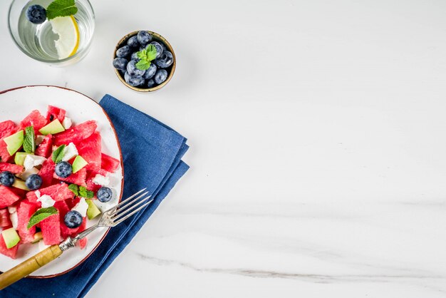 Summer food concept, fresh cold watermelon salad with feta cheese, blueberry, avocado 