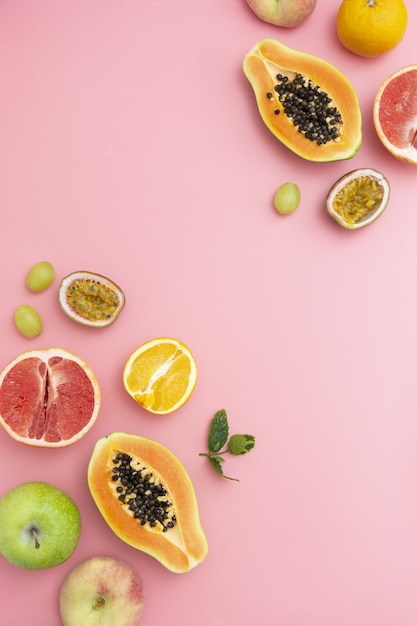 Summer food with fresh fruits frame, copy space. Pink background.