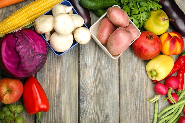 Summer frame with fresh organic vegetables and fruits on wooden background