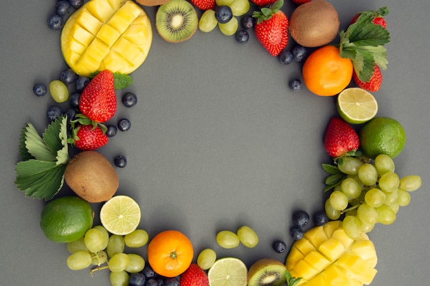 summer fruits, frame. Grapes, mango, strawberry, blueberry, kiwi, mint, lime.