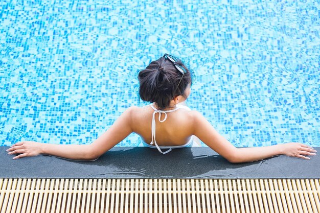 Summer fun in holiday Happy beautiful woman lifestyle relaxing in luxury swimming pool summer holiday vacation concept