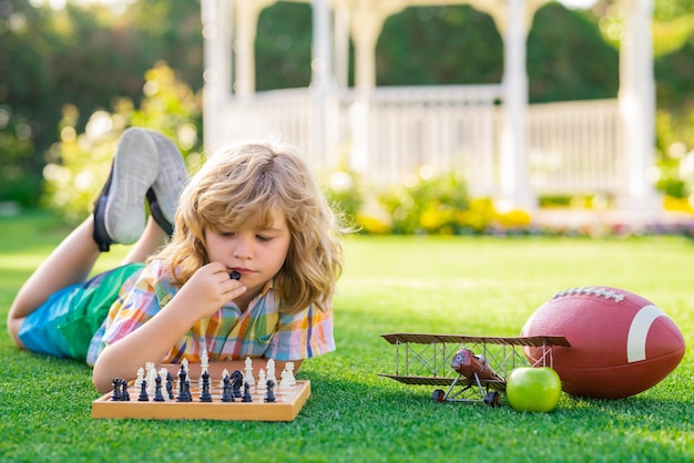 写真 夏のゲームや夏の pa でチェスについて考えている子供の早期開発少年のための野外活動