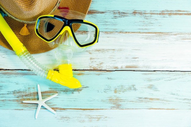 Summer hat, starfish and snorkel set on a wooden table