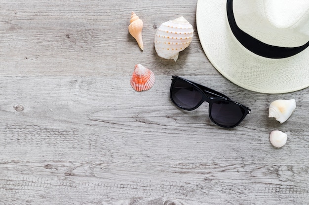 Summer hat and sunglasses on wooden table