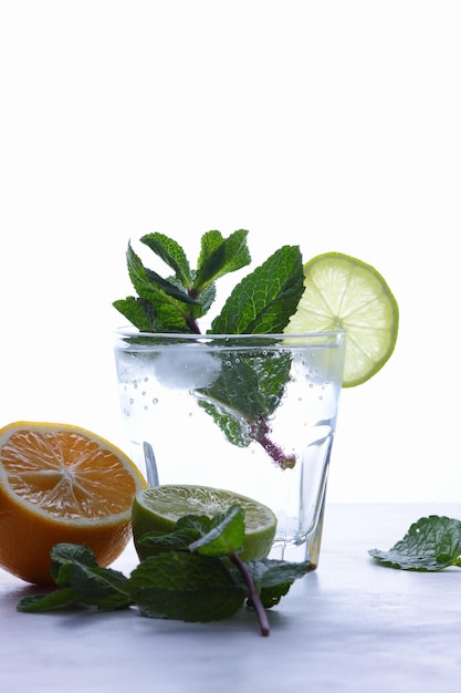 Summer healthy lemonade citrus water or mojito cocktails with lime lemon orange ice and mint Water with lemon Closeup