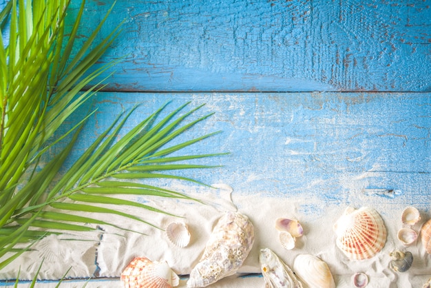 Summer Holiday Background. Old blue wooden plank table with seashell, starfish and beach sand