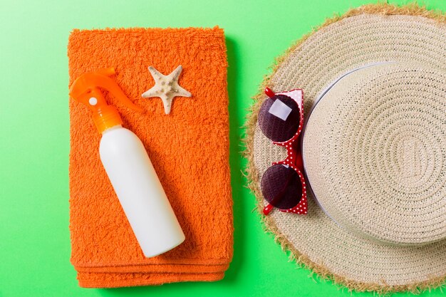 Summer holiday background with beach accessories on colored background top view with copy space