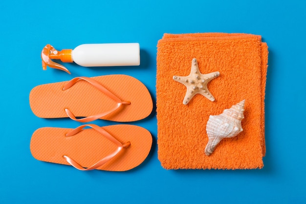Summer holiday background with beach accessories on colored background top view with copy space