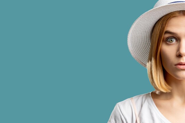 Summer holiday Canceled vacation Surprised blonde woman in white hat looking at camera isolated on blue copy space Travel offer Advertising background