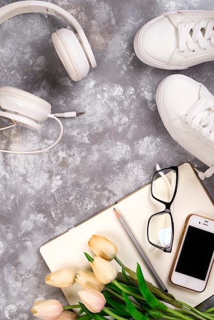 Summer holiday concept: smartphone , white sneakers, notepad, headphones, pen