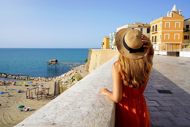 イタリアの夏の休日テルモリ モリーゼ イタリアの古い町を訪れる若い旅行者の女性の背面図