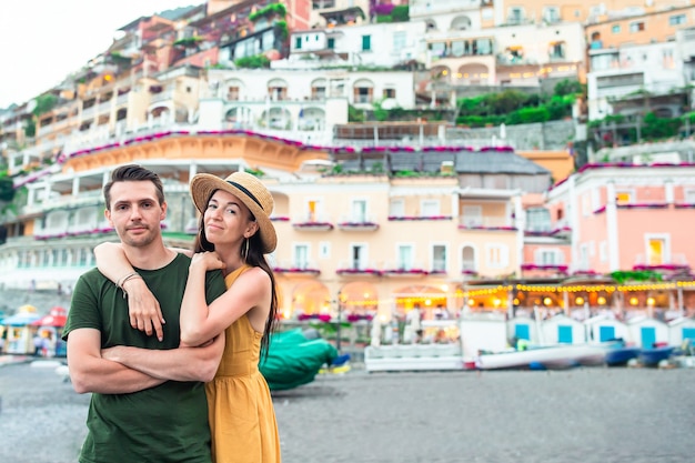 Summer holiday in Italy. Young couple in Positano village on the background, Amalfi Coast, Italy