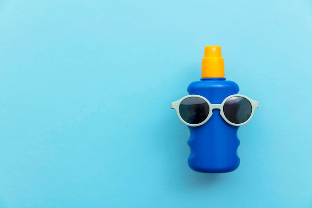 Summer holiday vacation background. Bottle of sun cream with sunglasses.