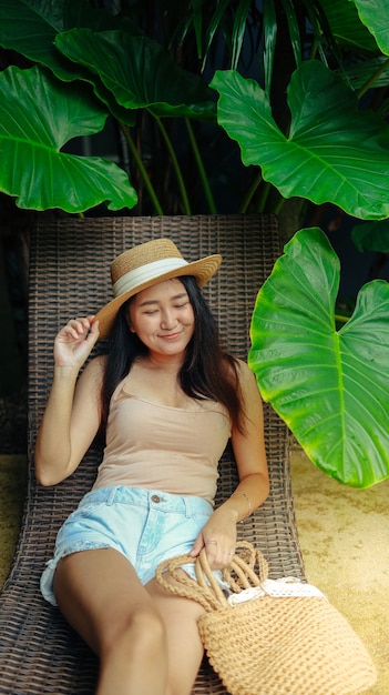 Summer holiday young asian beautiful woman relaxing in swimming\
pool at spa resort beautiful tropical beach front hotel resort with\
swimming pool