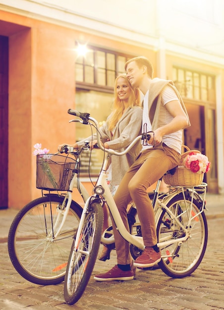 summer holidays, bikes, love, relationship and dating concept - couple with bicycles in the city