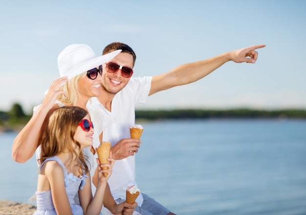 summer holidays, celebration, children and people concept - happy family eating ice cream