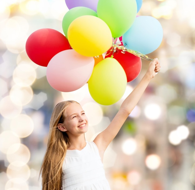 Foto vacanze estive, celebrazione, famiglia, bambini e concetto di persone - ragazza felice con palloncini colorati