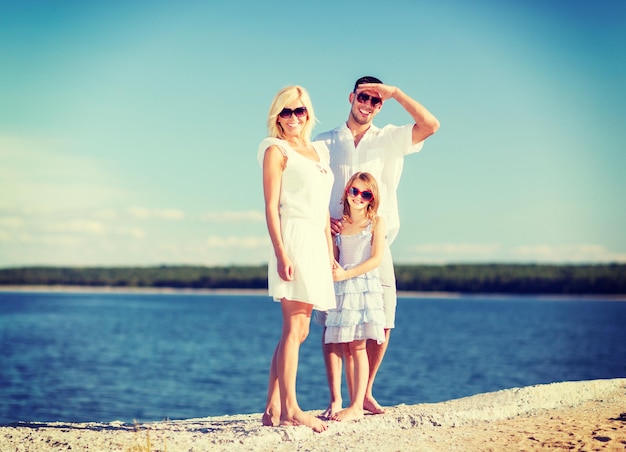 летние каникулы, дети и концепция людей - счастливая семья с голубым небом