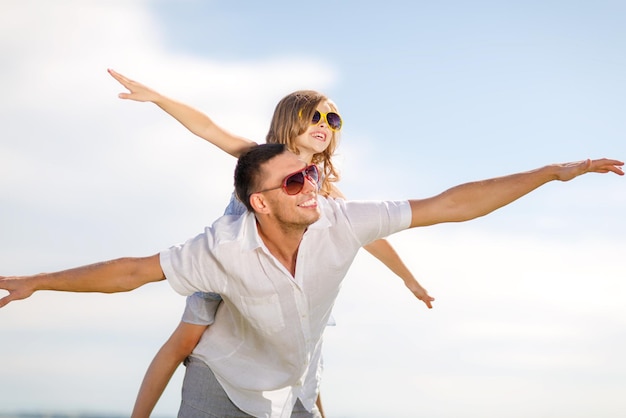 summer holidays, children and people concept - happy father and child in sunglasses over blue sky