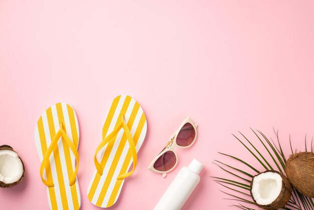 Summer holidays concept top view photo of sunglasses striped yellow slippers sunscreen