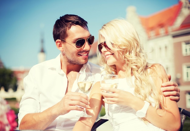 여름 휴가 및 데이트 개념 - 도시의 카페에서 와인을 마시는 커플