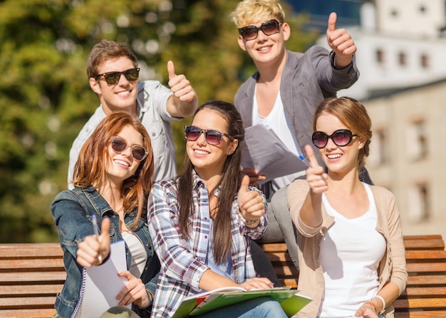 Vacanze estive, istruzione, campus e concetto di adolescenti - gruppo di studenti o adolescenti con libri, quaderni, file e cartelle