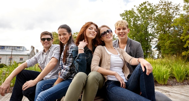 summer holidays, friendship, leisure and teenage concept - group of students or teenagers hanging out at campus or park