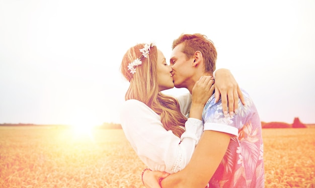 Photo summer holidays, love, romance and people concept - happy young hippie couple kissing outdoors