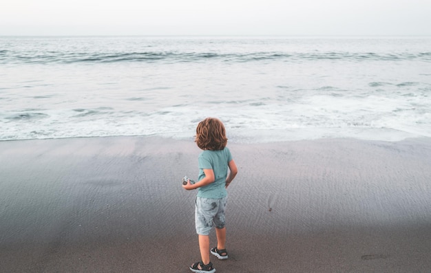 Vacanze estive in mare bambino che gioca nell'oceano ragazzo del bambino che si diverte sulla spiaggia vacanze per bambini e