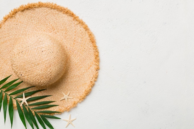 Summer holidays Summer concept with straw hat and tropical leaf Flat lay top view copy space