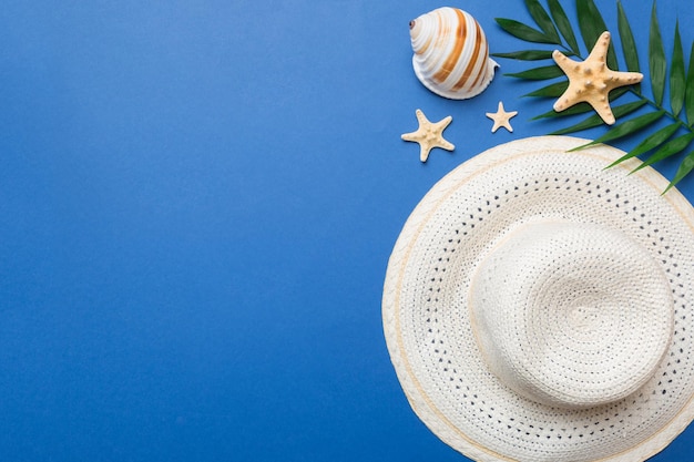 Summer holidays Summer concept with straw hat and tropical leaf Flat lay top view copy space