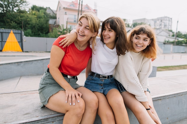 Summer holidays and teenage concept - group of smiling teenagers hanging out outside.