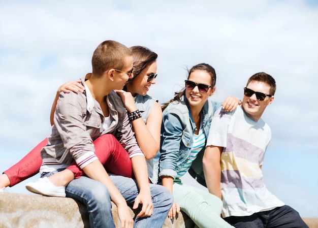 летние каникулы и подростковая концепция - группа подростков, висящих на улице